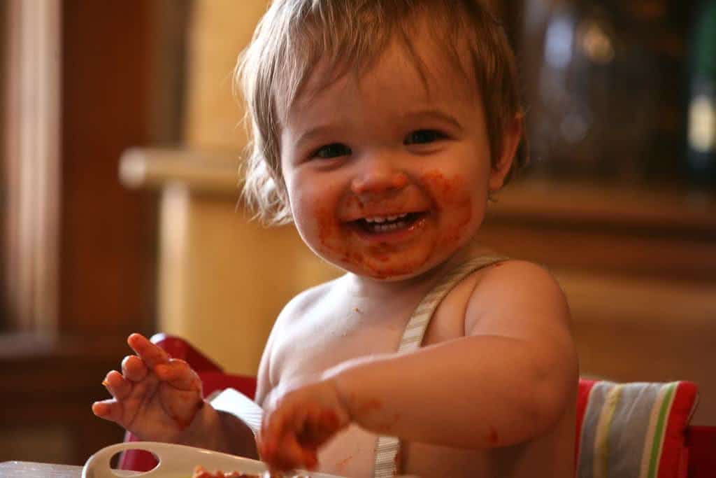 Criança suja de molho de tomate